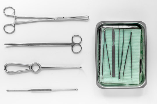Surgical instruments and tools including scalpels, forceps and tweezers on white table top view