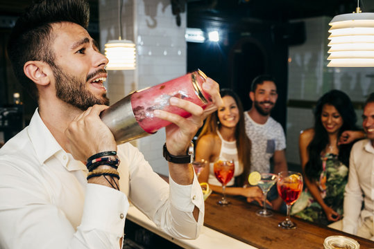 People watching bartender in bar