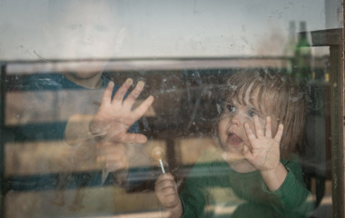 Obraz na płótnie Canvas Caucasian children behind glass