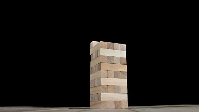 Wooden beams puzzles gather in one tall tower. Stop motion