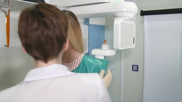 Female patient undergoes panoramic skull scan of teeth