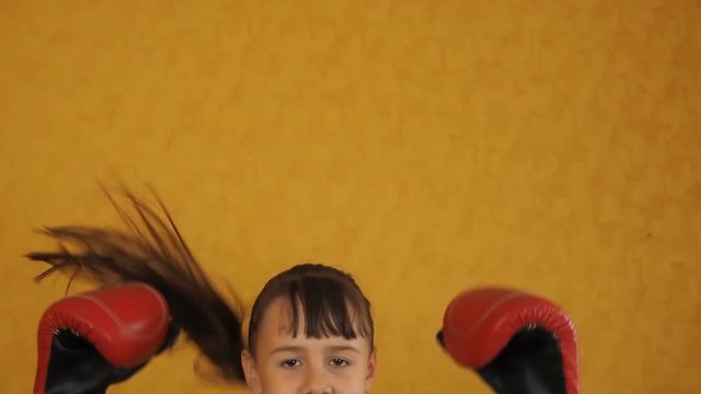 Emotions of a little girl in boxing gloves. Happy girl in boxing gloves.