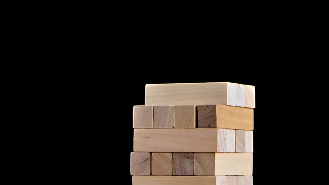Tower blocks jenga game gather in building. Stop motion, black background