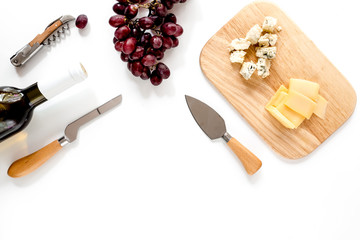 Bottle of red wine with cheese and grape aperitive on white background space for text top view