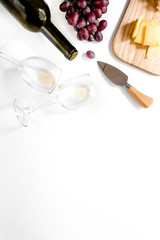 Set for drinking wine with cheese and red grape on white background copyspace top view