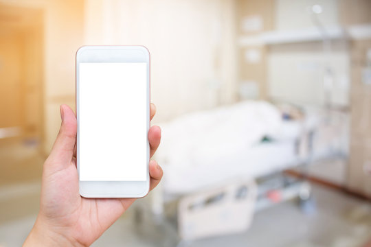 Hand hold mobile phone with abstract hospital room interior