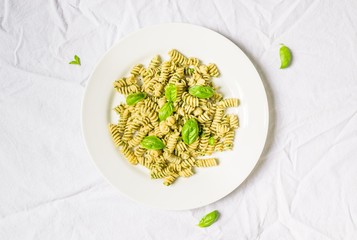Pasta with basil and cheese pesto against white background