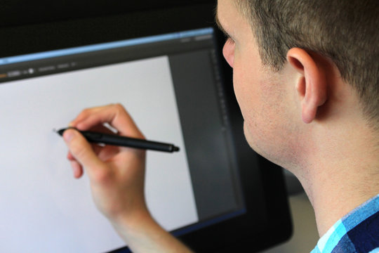This is a picture of a man drawing on a tablet. 