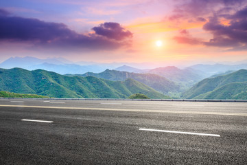 asphalt road and mountain at sunset