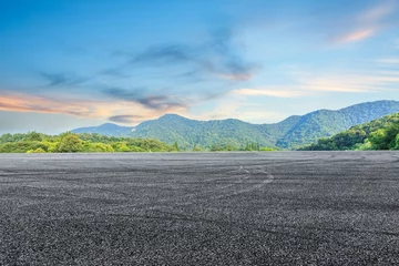 Stof per meter asfaltweg en bergachtergrond © ABCDstock