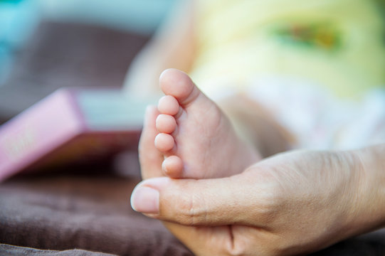 Baby feet in mother hands.