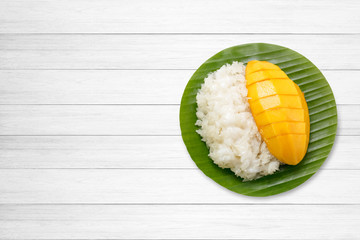 dessert sweet sticky rice with mango coconut milk on white wooden.