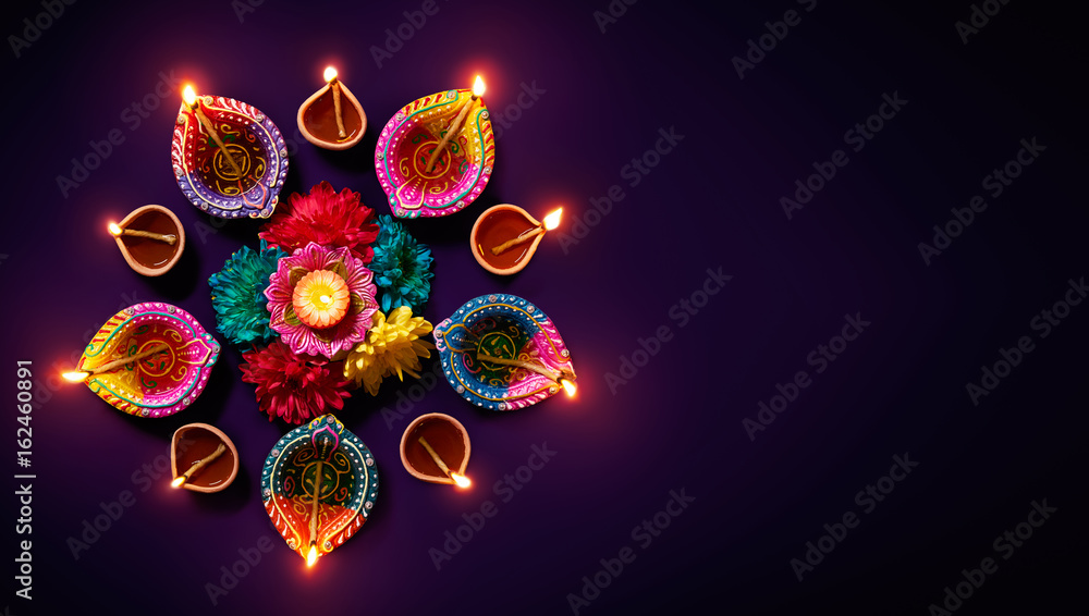 Wall mural colorful clay diya lamps with flowers on purple background