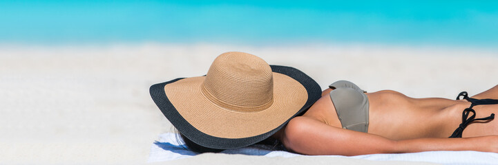 Beach relaxation woman sleeping with hat banner sun tanning covering her face with sunhat for uv...