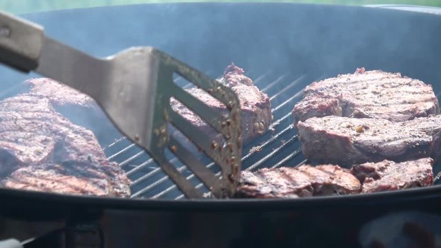Man's hands cooking steak on grill