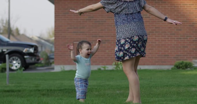 Toddler Boy And Mother Dancing In Front Lawn - Family Dance Off Time