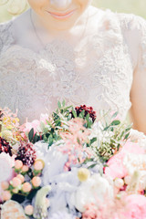 bride's hands hold beautiful bridal bouquet of peony. fine art photography.