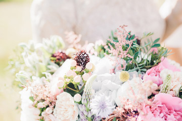 bride's hands hold beautiful bridal bouquet of peony. fine art photography.