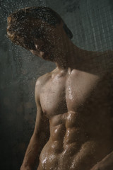 Nude young man taking shower studio portrait