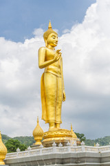The respectable golden Buddha statue. Standing outdoors in the beautiful sky.