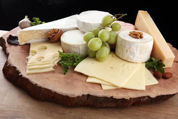 Cheese platter with different cheese on brown wooden plate
