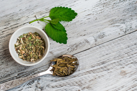 Leaves of green tea and collection of useful herbs in a bowl. The concept of healthy eating.