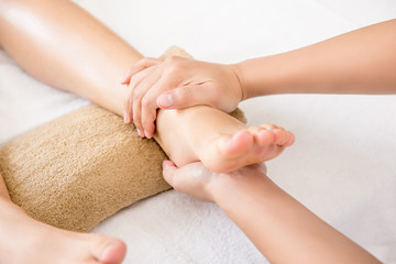 Fototapeta na wymiar Therapist giving traditional thai foot massage to a woman