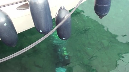 Kas, Turkey -- March 17, 2015: Filming the 1st stage of the Underwater cleaning activities at Kas harbor -- Diver works under the boat's bottom at harbor