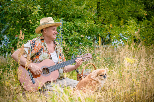 Old european man on a picnic with his dog have fun and sing song