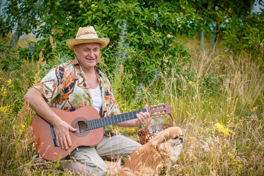 Old european man on a picnic with his dog have fun and sing song