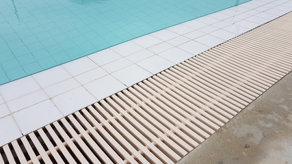 White drainage rail with white tile beside the swimming pool