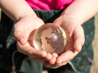Crystal globe in children's palms