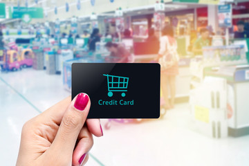 Woman holding credit card with blurred payment point background