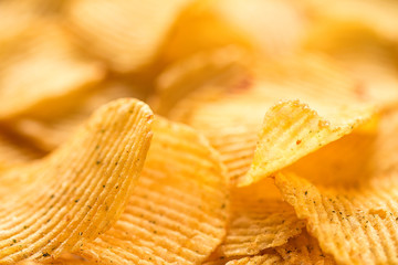 Yellow salted potato chips as background, closeup
