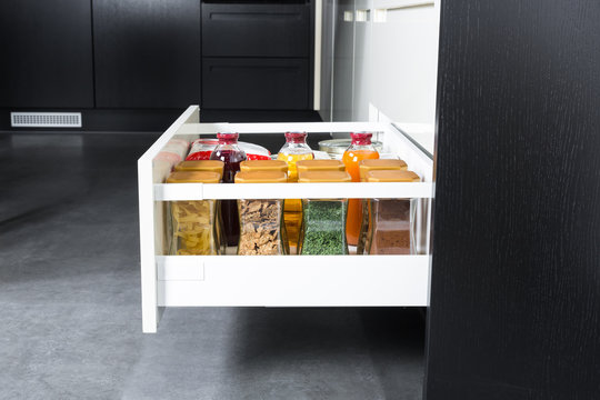 Side view of a spices and groceries organized in a modern kitchen drawer. Kitchen design inspiration.