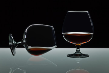 Two snifters of brandy on glass table