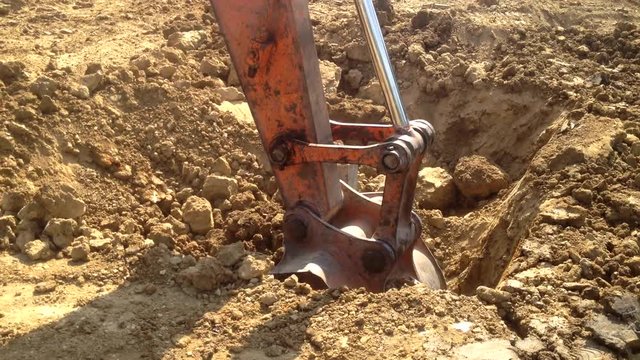 Excavator at work. backhoe mechanical shovel working on the field, dig around center pillar, with sound