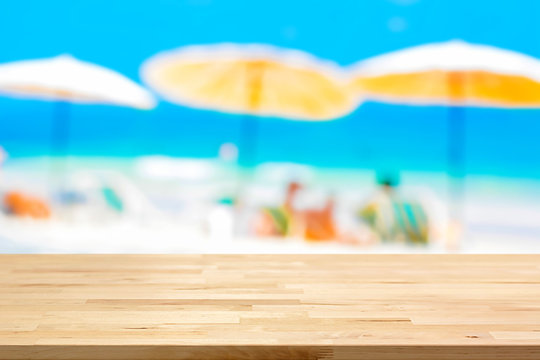 Wood table top on blurred beach background, summer holiday background concept