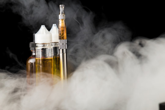 Electronic cigarette with bottles and big cloud of smoke