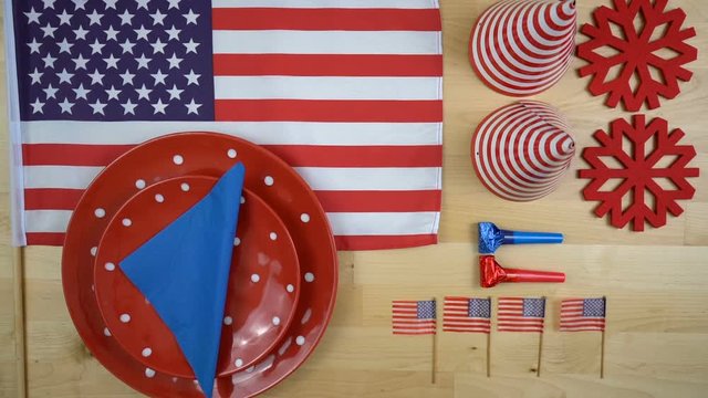 American theme party table overhead with flags and woman setting plates and cutlery, fast motion time lapse.