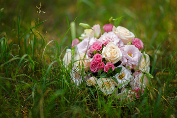 Round wedding bouquet lay in the grass.