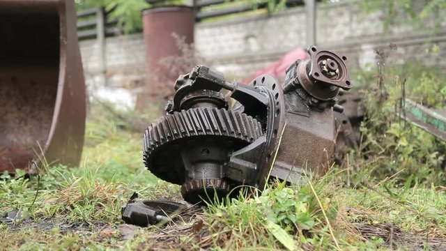 Slide shot of broken engine or transmission part of the truck or tractor on a dump site