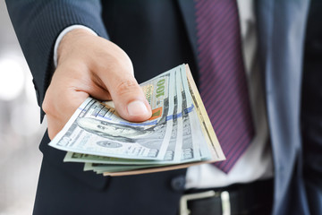 Businessman giving money, united states dollar (USD) bills