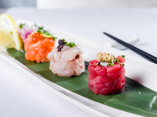 Mini raw fish sushi style with tuna, seabass and salmon, close up