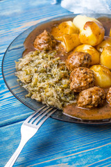 Homemade fried meatballs served with potatoes and cabbage.