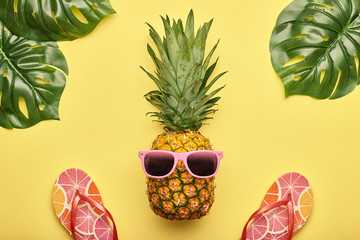 Fashion Pineapple. Bright Summer Color. Clothes Accessories set. Creative Art concept. Fashion woman Flip Flops, Tropical pineapple. Stylish girl. Minimal. Summer background on yellow. Top View