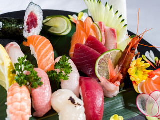 Fototapety  Zbliżenie mieszanego sushi i sashimi na czarnym naczyniu