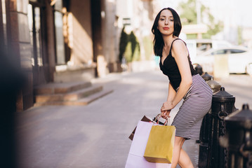 Fashionably dressed woman with colored shopping bags, shopping concept