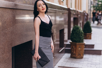 Fashionably dressed woman with colored shopping bags on the streets, shopping concept