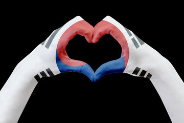 Fototapeta premium Hands flag of South Korea, shape a heart. Concept of country symbol, isolated on black.